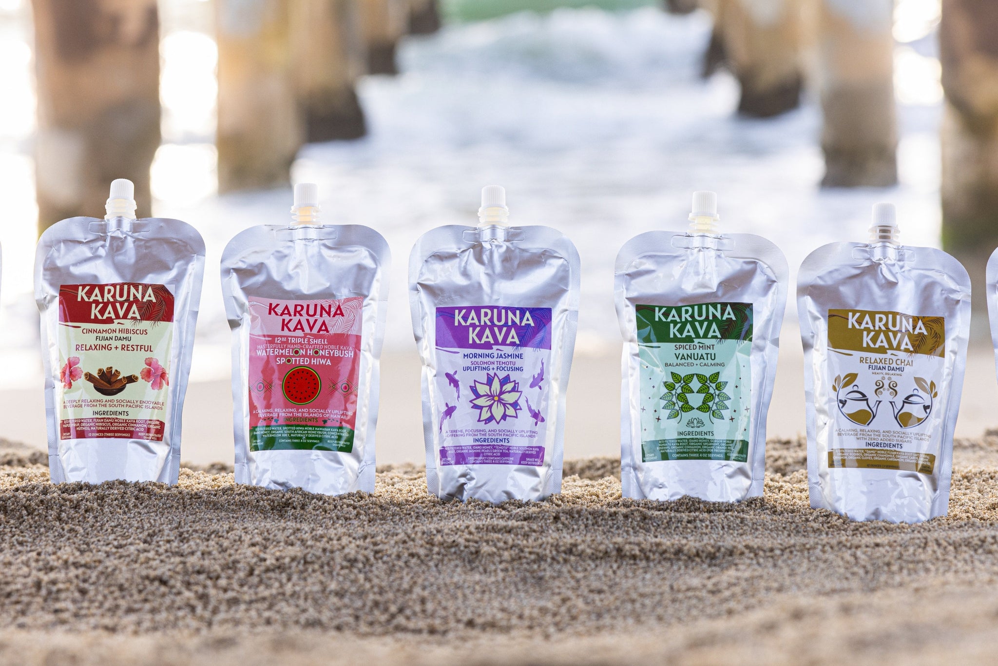 A variety of Karuna Kava kava beverages on sand, showcasing multiple flavors like Relaxed Chai and Fijian Damu, each offering relaxing and calming effects for evening enjoyment.

